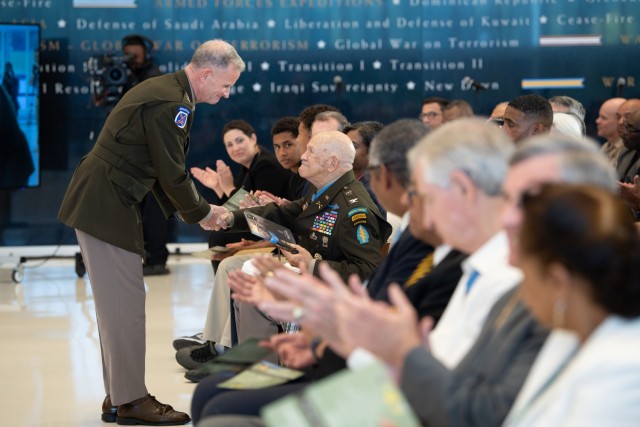 Director of the Army Staff, Lt. Gen. Walter Piatt presents a photo book to Medal of Honor recipient, retired Col. Paris Davis, at the National Museum of the U.S. Army, Fort Belvoir, Va., on Aug. 9, 2023. The photo book is personalized by the Secretary of the Army Christine E. Wormuth. (U.S. Army photo by Sgt. XaViera Masline)