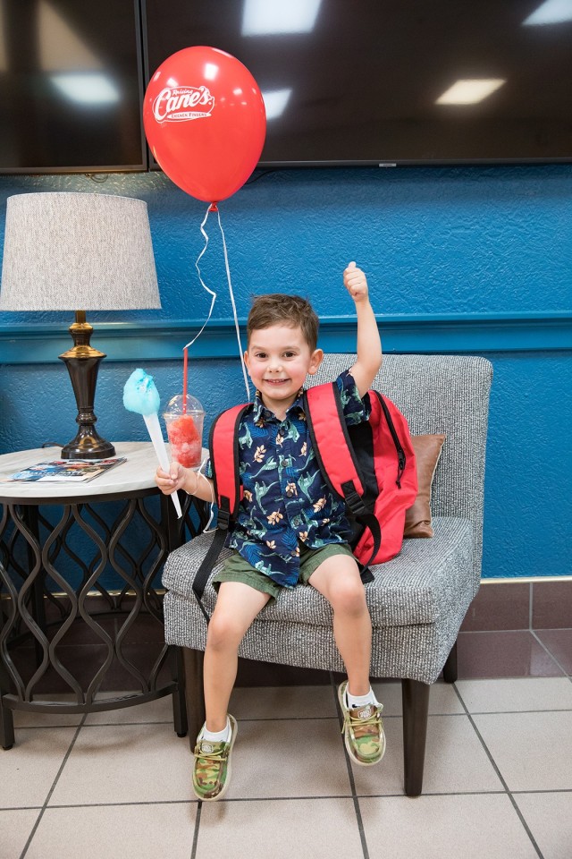 Lennox Melvin, son of Nadine Melvin and Warrant Officer 4 Steven Melvin, Operational Test Command, wears his newly acquired red backpack Aug. 5 at the USO Back to School Birthday Bash. (U.S. Army photo by Blair Dupre, Fort Cavazos Public Affairs)