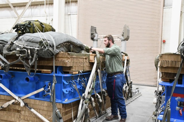 Air Delivery intern Jay Clark checks tags on a tub, verifying the weight which simulates the weight of a test vehicle and that the parachutes are connected.