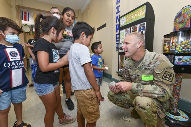 Lt. Col. Seam Riley, commander of the 187th Medical Battalion, greats students of Briscoe Elementary School during a school supply donation on Aug. 11, 2023. The battalion organized a school supply drive to help 315 students and families.