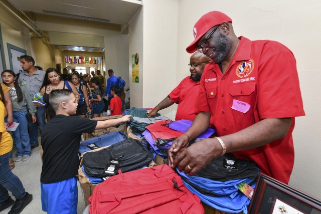 Royal Arch Masons Darrin Prute and Clifford Massey hand out backpacks to students of Briscoe Elementary School on Aug. 11, 2023. The Royal Arch Masons joined the 187th Medical Battalion in donating school supplies to 315 families during a back to school supply drive.