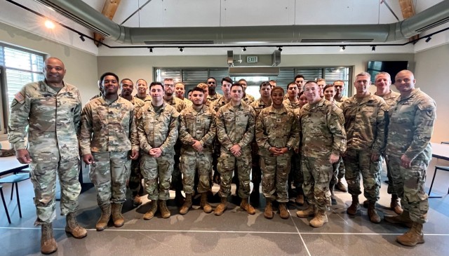 Lt. Gen. Kevin Vereen and Sgt. Maj. Michael Perry pose in the dining facility with a group of Soldiers.