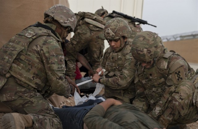 U.S. Army Reserve Sgt. Dexter James, left, Spc. Brenda Rodriguez-Alvarado, center, and Spc. Logan Burns, right, with the 143d Expeditionary Sustainment Command, work together to stabilize and apply gauze to the leg of an injured role player during an active shooter drill at King Faisal Air Base, Jordan, May 19, 2023. Knowing how to respond appropriately if an active shooter is present is essential to prevent loss of life. While the run, hide, and fight strategy is commonly taught to Soldiers throughout the U.S. Army, Soldiers assigned at KFAB put their knowledge to the test in a training environment.