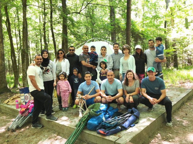 Ambassadors Mark and Sheryl Wise (fourth and fifth from top right) pose with a group of international military students assigned to the Maneuver Center of Excellence and Fort Moore, Ga., along with their families during a camping trip April 29, 2018, at Uchee Creek Campground, Ala. 