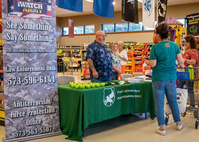 John Seman, Assistant Installation Antiterrorism officer, and Lena Hartmayer, Plans and Operations specialist, speak with Commissary shoppers Aug. 11 as part of an outreach event to help recognize Antiterrorism Awareness Month. One of the key messages of the Army wide campaign is that everyone plays a role in protecting their community from acts of terrorism. 