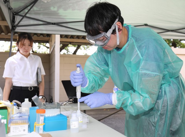 Dr. Hiroko Ejiri, a professor at the National Defense Medical College, performs pathogen analysis using a field lab as part of a knowledge-sharing event at Camp Zama, Japan, Aug. 21, 2023.