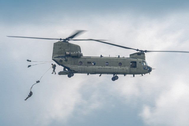 U.S Army paratroopers  jump out of a CH-46 Chinook helicopter during the annual Leapfest International Parachute Competition and training event hosted by the Rhode Island National Guard on August 5, 2023.