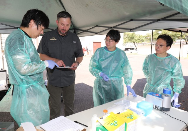 Dr. Gary Crispell, second from left, chief of Public Health Command–Pacific&#39;s Environmental Molecular Biology Laboratory, discusses how to perform pathogen analysis using a field lab as part of a knowledge-sharing event at Camp Zama, Japan, Aug. 21, 2023. Crispell and other PHC-P experts showed a handful of professors from the National Defense Medical College and interns in U.S. Army Garrison Japan’s summer internship program how to conduct the process in an austere setting. 