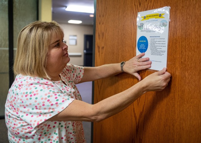 Wendy Couch, General Leonard Wood Army Community Hospital patient advocate, places a Patient and Family Partnership Council volunteer advertisement on the door of her office Tuesday. Hospital leaders are seeking individuals who want to get involved in the council to meet regularly to provide feedback on their experiences as patients here and help plan changes to improve overall care at the hospital. 