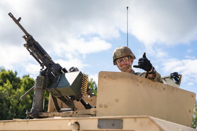 U.S. Army Pfc. Buckley Ryan, military police assigned to the 143rd Military Police Company, 192nd Military Police Battalion, Connecticut Army National Guard, poses for a photo from the turret of his High Mobility Multipurpose Wheeled Vehicle, or humvee, before vehicle gunnery at Fort Drum, New York, Aug. 13, 2023. Despite this being his first annual training period, and first time manning the M240L machine gun as a vehicle gunner, Ryan successfully engaged all targets and became the fifth gunner in his unit to qualify. (U.S. Army photo by Sgt. Matthew Lucibello)