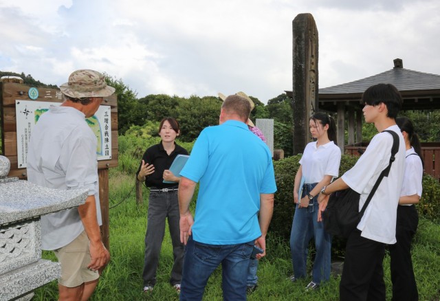Yukiko Muroi, second from left, speaks about the Battle of Mimasetoge during a site survey in Aikawa, Japan, Aug. 23, 2023. Muroi and another intern, Anon Anami, developed self-guided tours as part of their capstone projects for U.S. Army Garrison Japan&#39;s summer internship program.