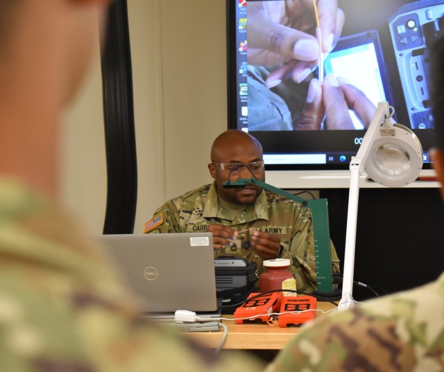 Sgt. 1st Class Micheal Carroll, instructor at the U.S. Army Signal School, trains students in one of the school’s mobile fiber labs. 
