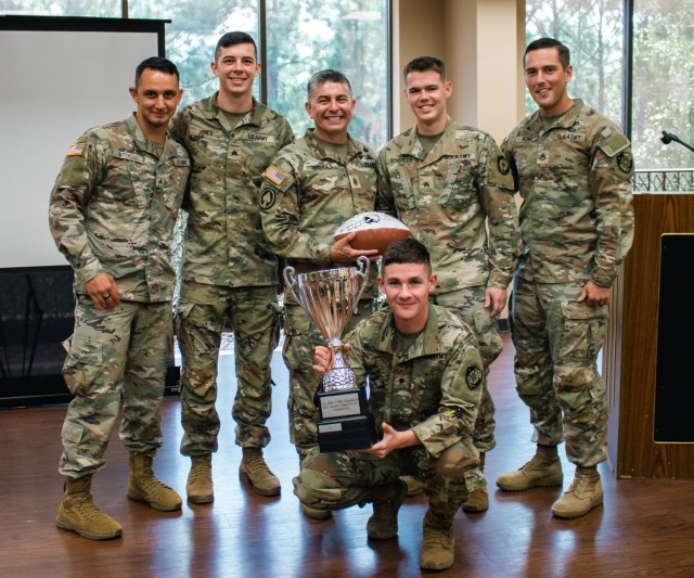 Army Cyber Command (ARCYBER) Command Sgt. Maj. Jack Nichols (center) poses for a photo with the Army Cyber Protection Brigade team and their trophy for winning the ARCYBER 2023 Best Squad Competition, at Fort Gordon, Ga., Aug. 25, 2023. The team...