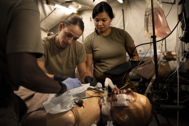 U.S. Army Capt. Ashely Sarlo, a critical care nurse attached to the 240th forward resuscitative surgical detachment, and Spc. Connie Sariraksa, a licensed practical nurse attached to the 7454th medical operational readiness unit, simulate experimental postoperative critical care at Camp Grayling, Mich. on Aug. 12, 2023, during Northern Strike 2023(NS23).Exercise NS23 is a premiere reserve component training even that integrates both U.S. and partner nation readiness training to build interoperability and strengthen partnerships in an all-domain environment. (U.S. Air National Guard photo by Staff Sgt. Jacob Cessna)