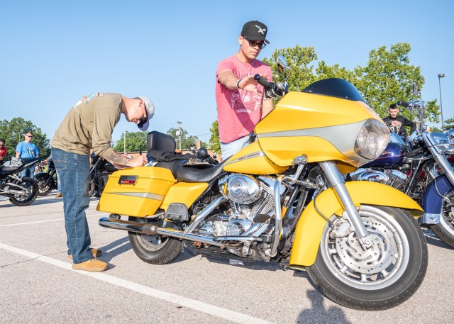 Sgt. Michael Hemminger (white hat) and Sgt. Ryan Lira (black hat) from the Combat Training Company perform T-CLOCS (tires, controls, lights, chassis and stand) inspections on their motorcycles before taking off on Friday’s Thunder in the Fort safety motorcycle ride.