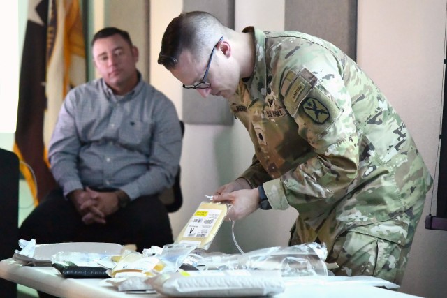 An Army officer demonstrates the process of preparing freeze dried plasma during the U.S. Army Medical Capability Development Integration Directorate Role 1 Limited Objective Exercise held at Fort Sam Houston, TX from August 28 through the 31st. The tabletop exercise highlighted challenges, gaps, and/or requirements across the Doctrine, Organization, Training, materiel, Leadership and Education, Personnel, Facilities and Policy (DOTmLPF-P) spectrum, including extended care due to potential evacuation delays.