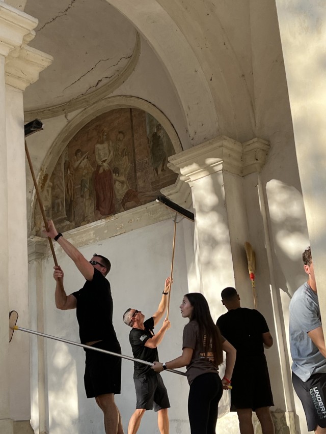 VICENZA, Italy – Volunteers of the Alpini groups of Vicenza, the Order of Malta alongside the American Soldiers and their family members clean the leaves from the porticoes, and also armed with brooms, mops and poles remove cobwebs from arches and columns during the cleanup of the arcades and the area leading up to the Basilica of Monte Berico Aug. 26, 2023. The annual event is part of an ongoing partnership to prepare the site for the upcoming festivities of the patron saint “Virgin Mary of Monte Berico” and the arrival of thousands of pilgrims from all over the region on Sept. 8.