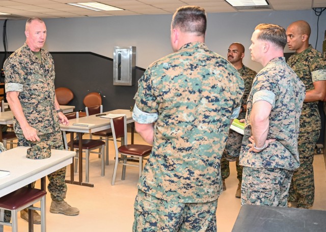 Marine Brig. Gen. Michael McWilliams, 2nd Marine Logistics Group commanding general, talks with Marine Corps Detachment Fort Leonard Wood leadership Wednesday while visiting the classrooms at Training Area 61, where Motor Transport Instruction Company instructors teach the Vehicle Recovery Course.