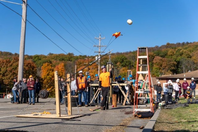A crowd watches as a catapult, built by the Dover Dunkers from Dover Middle school, launches a pumpkin into Lake Picatinny during the 5th Pumpkin Sling competition at Picatinny Arsenal on October 21, 2022. Five New Jersey schools competed in the event, which is part of Picatinny’s STEM Educational Outreach Program. 