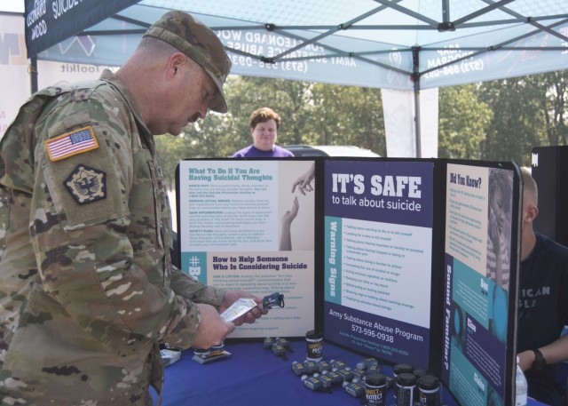 Staff Sgt. Matthew Leary, a horizontal construction engineer with the 554th Engineer Battalion, looks through giveaways at a suicide prevention event today on Gerlach Field. 