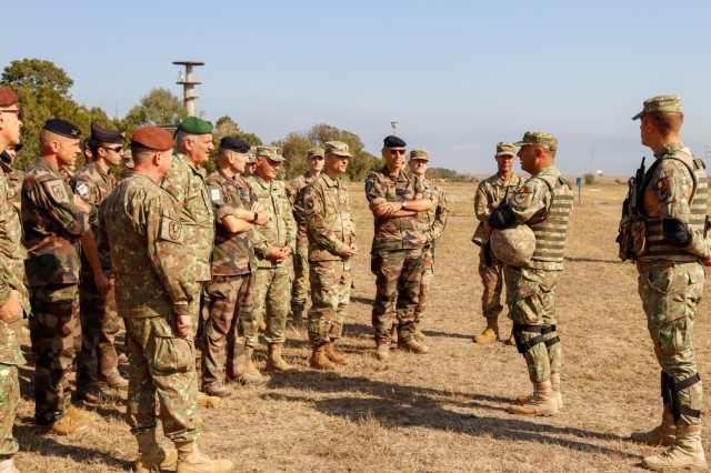 U.S., France and Romania military senior leaders listen to a brief by a Romanian soldier during exercise Arcane Thunder 23 distinguished visitor day. 
