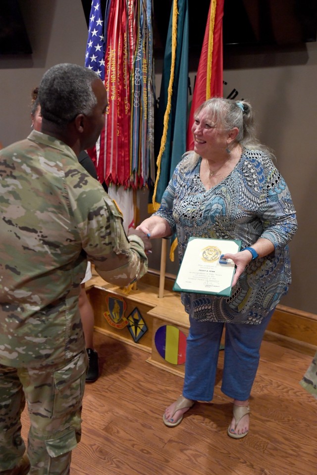 Peggy Penn shakes the hand of Brig. Gen. Jason E. Kelly, Fort Jackson commander, after being awarded for her 50 years of service on post.