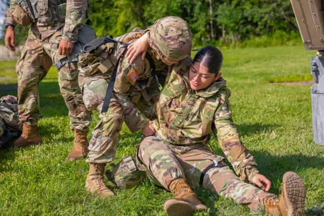 Connecticut Army National Guard Spc. Ashley Hornung, left, a combat medic specialist assigned to the 141st Medical Company (Ground Ambulance), helps Connecticut Army National Guard Spc. Dyamanni Vasquez, right, military police assigned to the 143rd Regional Support Group, stand up during a mass casualty exercise at Fort Drum, New York, Aug. 13, 2023. (U.S. Army photo by Sgt. Matthew Lucibello)