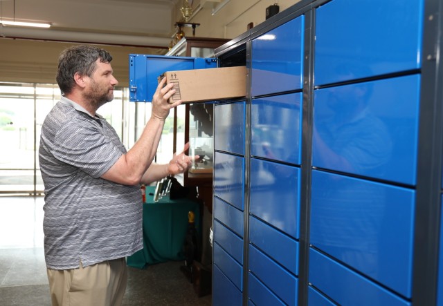 Corey Scott, postal operations chief for Navy Fleet Mail Center Yokohama, places a package inside an Intelligent Locker System that was recently installed at Yokohama North Dock, Japan, Sept. 15, 2023. Camp Zama plans to soon install similar smart lockers at its mailroom that will help personnel securely collect their packages at any time.