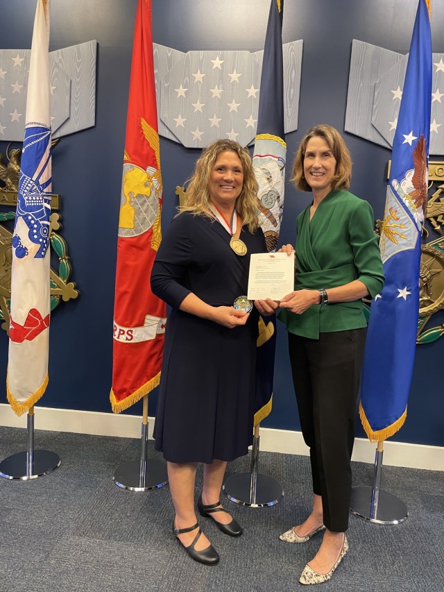 SDDC Deputy to the Commanding General Kristina O’Brien (right) presents Brenda Seubert with an SDDC coin and congratulatory note following the Spirit of Hope award presentation ceremony held in the Pentagon’s Hall of Heroes, Sept. 14, 2023. Seubert was the Army recipient of the Department of Defense award. 