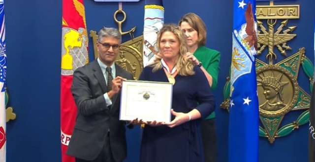 Honorable Ashish Vazirani, Acting Under Secretary of Defense for Personnel and Readiness, presents Brenda Seubert with the Department of Defense Spirit of Hope award during a ceremony held in the Pentagon’s Hall of Heroes, Sept. 14, 2023. 