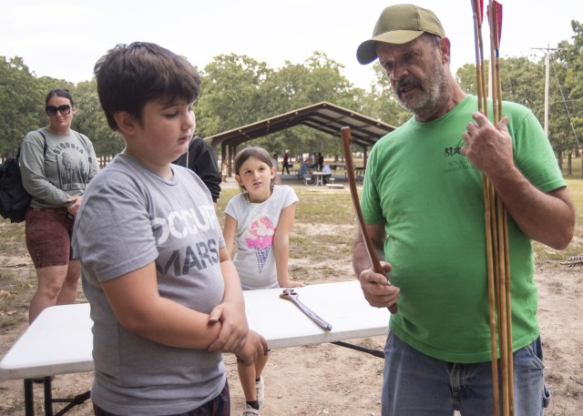 David Patterson, Missouri Atlatl Association president, explains how an atlatl works to 10-year-old Finn Carlson during the archaeology month event Sept. 14 at Colyer Park.