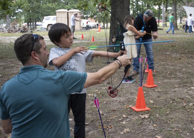 Six-year-old Eric Maddox, along with his sister, eight-year-old Arianna, learn the basics of archery Sept. 14 at Colyer Park during an outreach event organized by the Directorate of Public Works Environmental Division in support of Missouri...