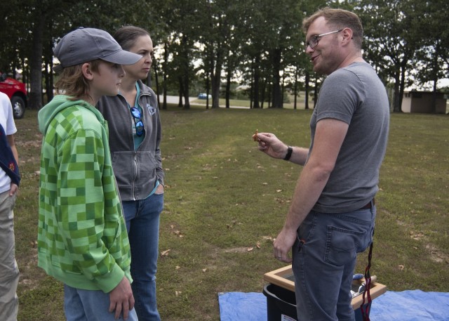 Andrew Phillips (right), a prehistoric archaeologist here, identifies artifacts brought to the archaeology month event Sept. 14 at Colyer Park by Steven Houser and his mother, Molly, who live south of the installation.