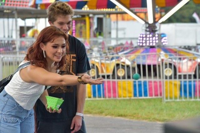 Jasmine Shimer and Garrett Finley play a game at Oktoberfest to win a goldfish.