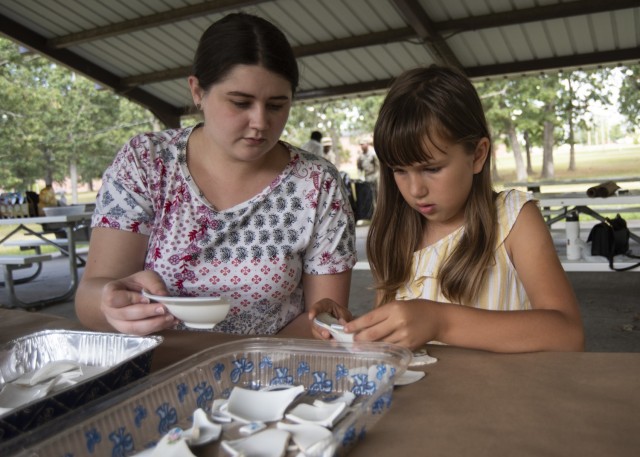 Eight-year-old Arianna Maddox works on putting broken ceramics back together with the help of Ashtan Piercy, from the Directorate of Public Works Environmental Division, during the archaeology month event Sept. 14 at Colyer Park.