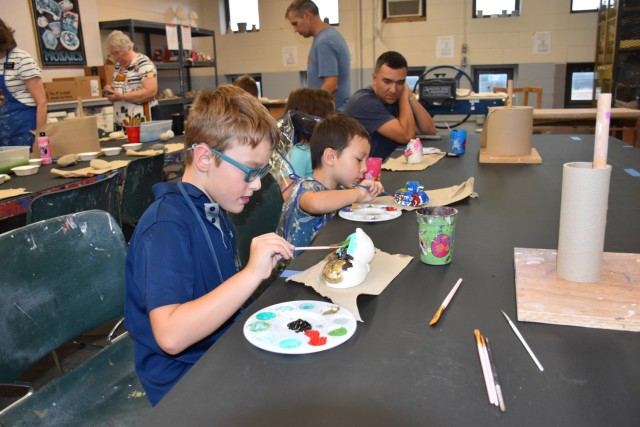 Capt. Ross Noffsinger, Carl R. Darnall Army Medical Center, looks on as his children, Brenna, 6, Lane, 3, and Kieran, 8, enjoy painting ceramics during the Resiliency Fun Fair Saturday at the Apache Arts & Crafts Center. (U.S. Army photo by Janecze Wright, Fort Cavazos Public Affairs)