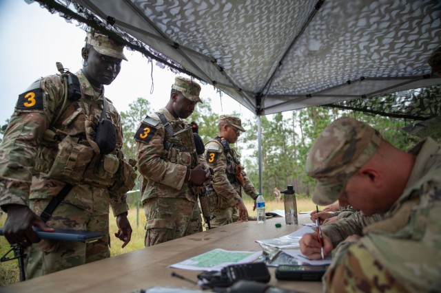 Left to right, Spc. Ousmane Drame, a native of Dakar, Senegal; Spc. Rollian Morgan, a native of Sevierville, Tennessee; and Sgt. Joshua Williams, a native of Kingston, Jamaica, all representing Army Futures Command, receive coordinates for a land navigation course during the 2023 Army Best Squad Competition at Fort Stewart, Georgia, Sept. 26 2023. The competition tests the squad’s proficiency in their warrior tasks and battle drills and identifies the most cohesive, highly trained, disciplined, and fit team that is ready to fight and win — while demonstrating commitment to the Army Values and Warrior Ethos.