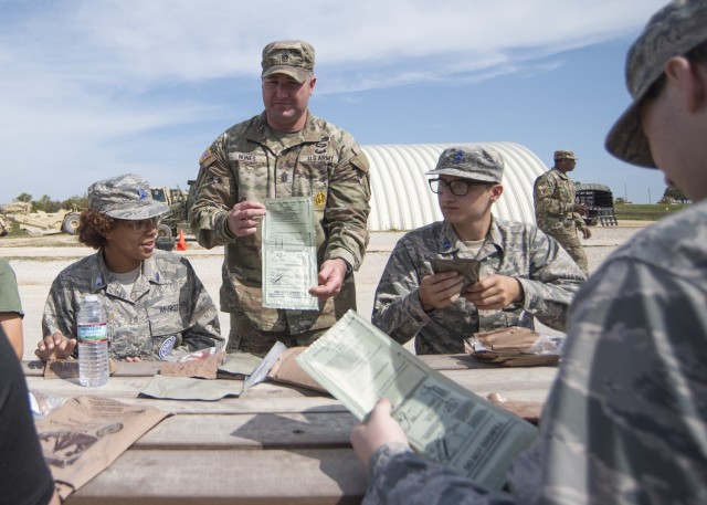 Kansas City Recruiting Battalion Command Sgt. Maj. Shane Nunes explains to Junior ROTC cadets how the heating element works in a Meal, Ready-to-Eat Saturday at Training Area 244.