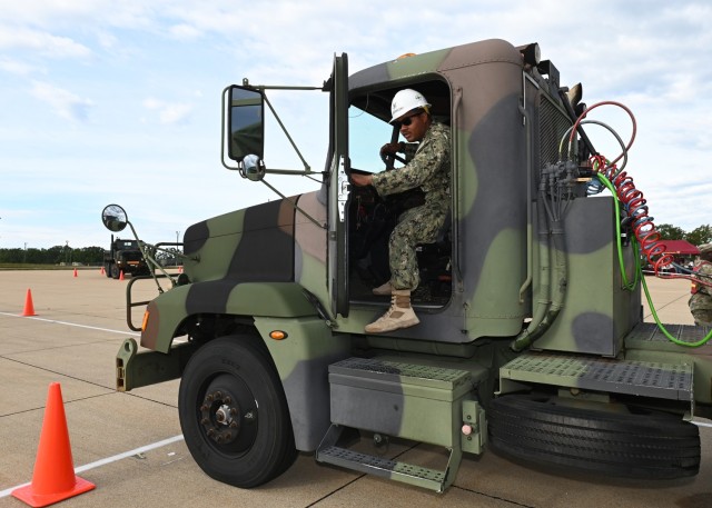 Navy Petty Officer 2nd Class Justin Sobieralski exits the Army’s M915 tractor trailer after completing the challenge of backing up the vehicle through a 90-degree turn during the Joint Service Truck Rodeo competition Friday at Training Area 228....