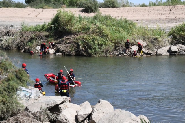 A group of firefighters from U.S. Army Yuma Proving Ground practice using ropes to hold an inflatable rescue boat in place on the Colorado River during a training exercise to receive their certifications to become Swift Water Rescue Technicians on...