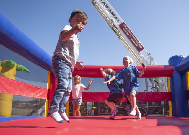 Children play in a bounce house Saturday in the Exchange parking lot during Fire Fest. The annual celebration – held each year around Fire Prevention Week, provides an opportunity for area firefighters to discuss fire safety with the local...