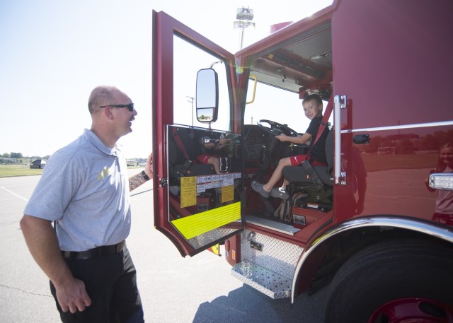 Six-year-old Jace Thomas gets behind the wheel of a fire truck Saturday in the Exchange parking lot with the help of Fort Leonard Wood Firefighter Russell Hobbs during Fire Fest. The annual celebration – held each year around Fire Prevention...