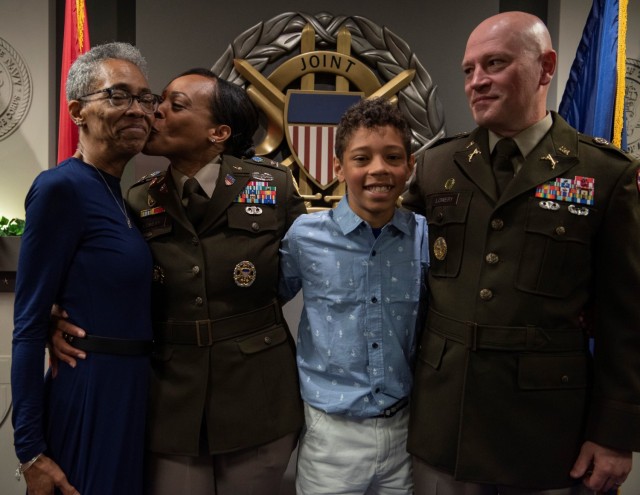 “Grandma Lucy,” left, gets a kiss from Joint Base Commander Col. Tasha Lowery in a family photo taken when Shawn Lowery, Sr., far right, was promoted to CW5 in May 2022 at the Pentagon in Washington D.C Also pictured is Shawn Lowery, Jr. 
