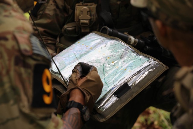 Staff Sgt. Andre Ewing, a native of Belton, Texas representing U.S. Army Special Operations Command, inspects a map during a situational training exercise of the Army Best Squad Competition at Fort Stewart, Georgia, Oct. 1, 2023. The BSC expands...