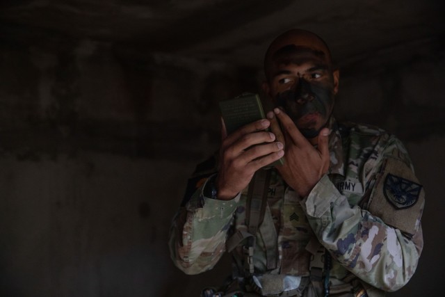 Sgt. Bradley Joseph, a native of Miami, Florida, representing Army Training and Doctrine Command camouflages his face during the patrol lanes portion of the 2023 U.S. Army Best Squad Competition at Fort Stewart, Georgia, Sept. 27, 2023. During Best Squad Competition, squads complete a fitness assessment, 12-mile foot march, weapons proficiency, hands-on Squad tasks, written exam, and essay, and culminate with a board interview with sergeants major from across the Army.