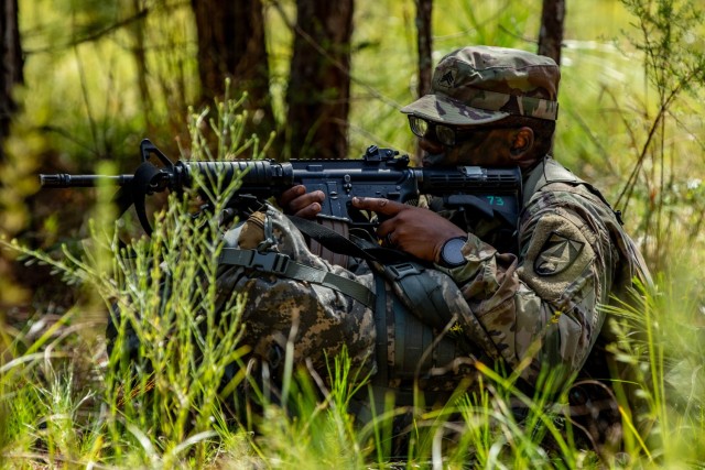 Sgt. Joshua Williams, a native of Kingston, Jamaica representing U.S. Army Futures Command, pulls security during a situational training exercise of the Army Best Squad Competition at Fort Stewart, Georgia, Oct. 1, 2023. This event required squads to perform squad-level tasks as they navigated through Fort Stewart’s training area.
