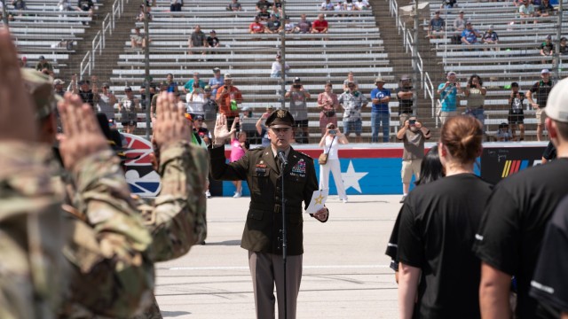 Future Army recruits and retained Soldiers stand united at center track of Texas Motor Speedway Sept. 24, as thousands of spectators look on before they take their oath of enlistment during the Autotrader EchoPark Automotive 400 series race. Their commitment symbolizes the enduring bond between the nation’s military and its citizens. (U.S. Army photo by Eric Franklin, Fort Cavazos Public Affairs) 