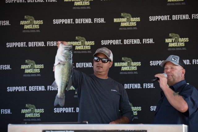 Dean Alexander, a boater, holds up the 5.64-pound largemouth bass that he caught during Fishing for Freedom. It was the largest fish of the competition. (U.S. Army photo by Blair Dupre, Fort Cavazos Public Affairs)