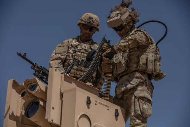 U.S. Army Staff Sgt. Devin Ward, left, with Charlie Company, 142nd Division Sustainment Support Battalion helps Cpl. Jose Cuevas, right, load a mounted M240B machine gun system during a company-level, live-fire qualification range, on Camp Buehring, Kuwait. Both NCOs fell under 1st Theater Sustainment command when it implemented its Leading Individuals From Experience coaching program. The coaching program is a long-term career long-term sustainable initiative designed to empower and equip NCOs with the necessary skills to excel not only in their military career but also the tools to overcome everyday obstacles in their personal lives ultimately building the foundation for their future success. (U.S. Army photo by Staff Sgt. Latasha Price)