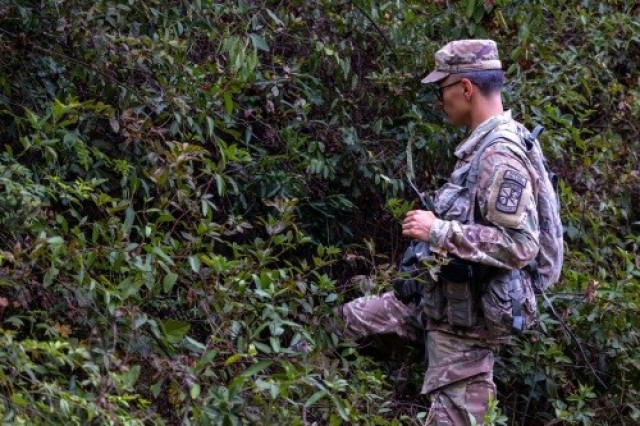 ROTC Cadet Daniel Martinez makes his way through thick brush on the way to a predesignated waypoint during a land navigation exercise on post.  